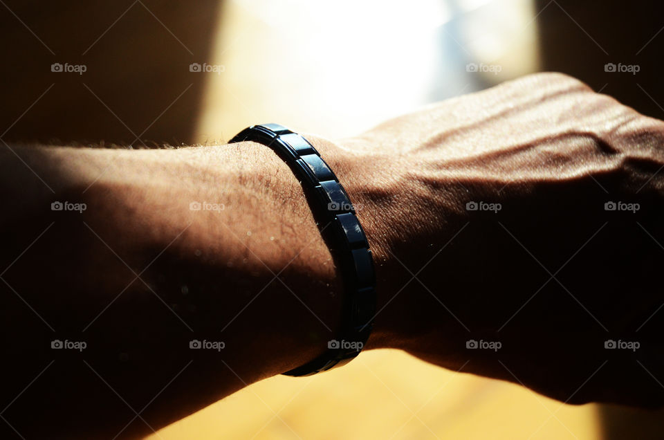 A man exercises his wrist wearing magnetic bracelet to help with the affects of arthritis.