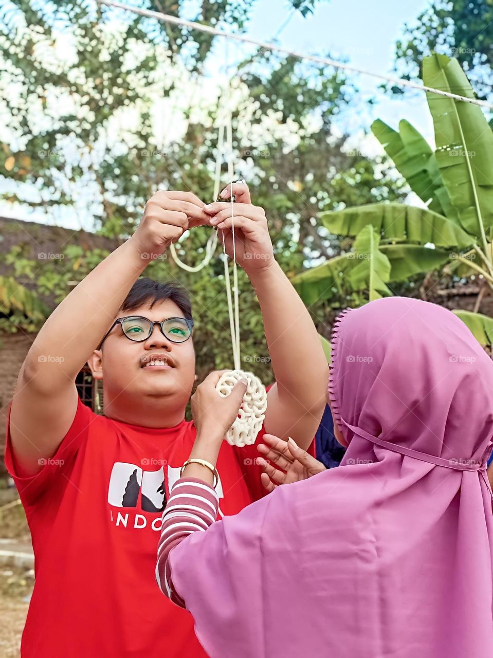 Potrait of a man is putting up crackers for a mother's cracker eating competition on Independence Day in Indonesia