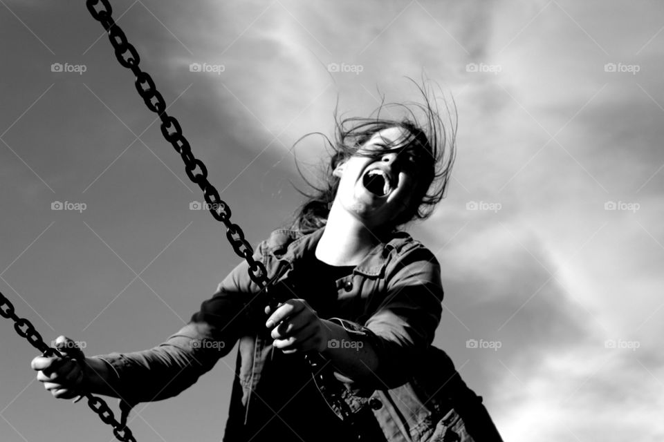 Close-up of a happy girl on swing in park