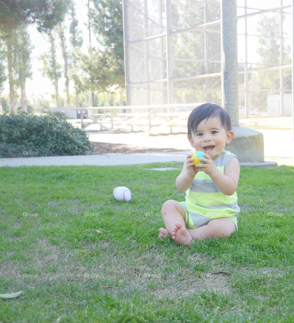 Cute little boy playing with ball in park