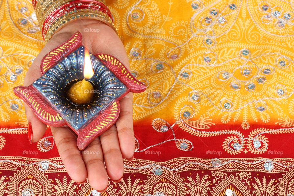 Beautiful Diwali diya oil lamp on a female hand