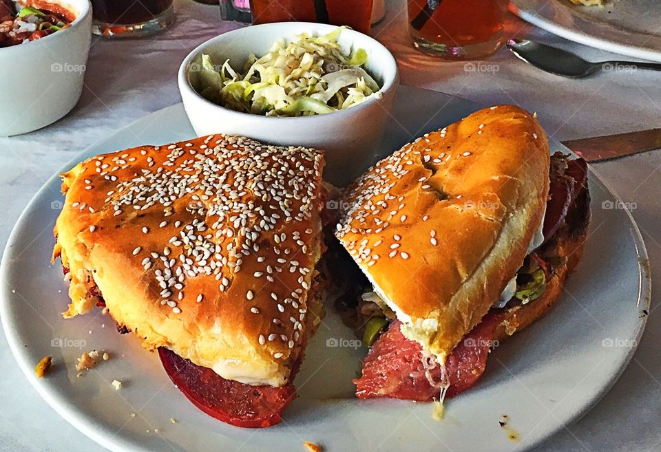 Ham , salami, pepperoni with olive salad and shredded lettuce on homemade bread with coleslaw on the side.