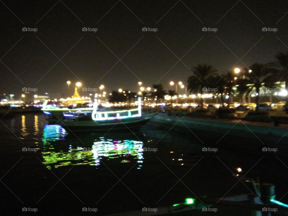 Corniche Dhow cruise docking at night.