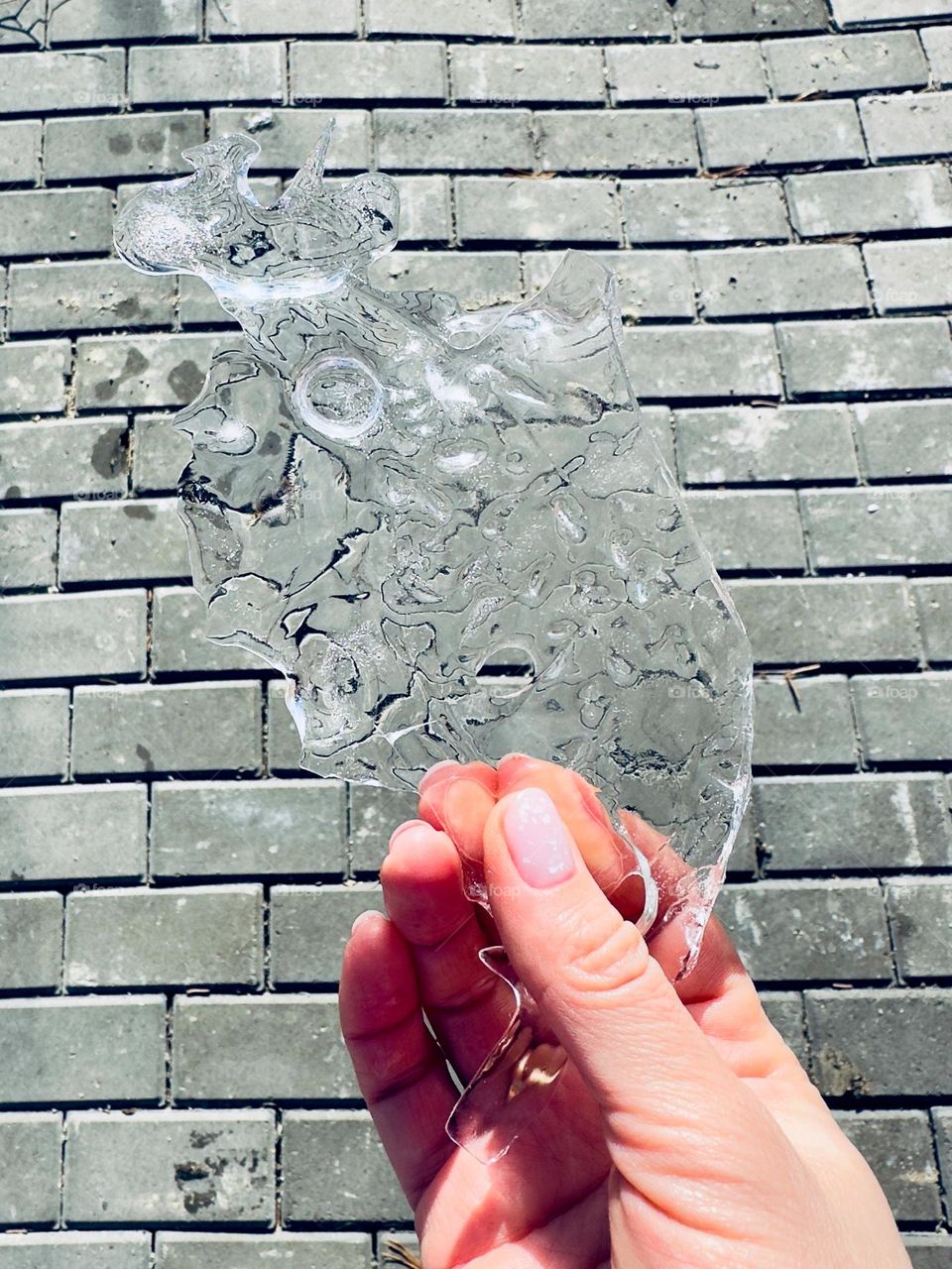 A piece of ice in a woman’s hand