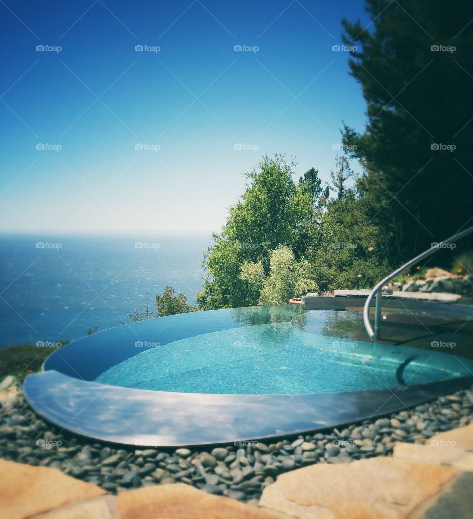 Infinity pool set into the cliff side looking over the Pacific Ocean at luxury resort: Post Ranch Inn situated in big sur, California 