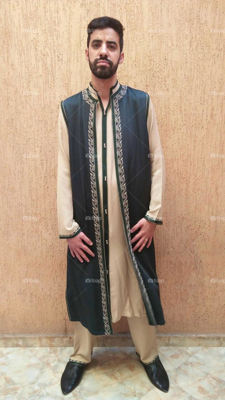 A handsome man wearing traditional moroccan clothes.