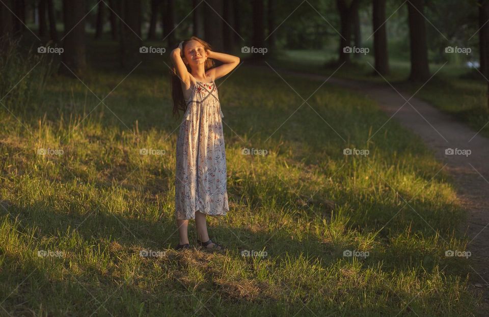 Moments of happiness, the girl smiles, sunny evening.