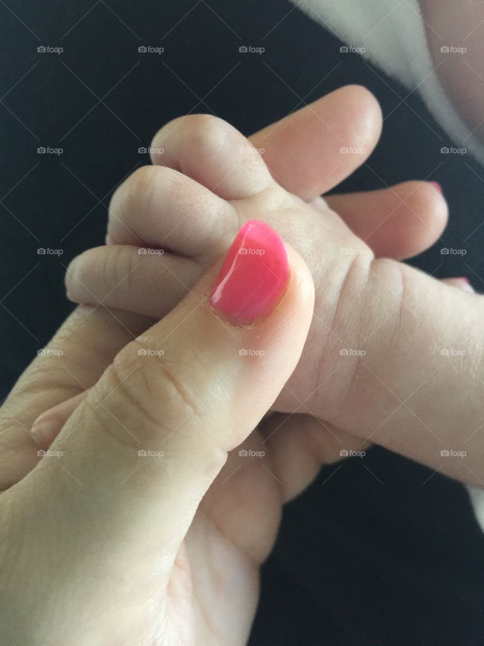 Baby holding hands with woman 
Baby Hand 
Woman Hand 
Pink Nails 
Precious 