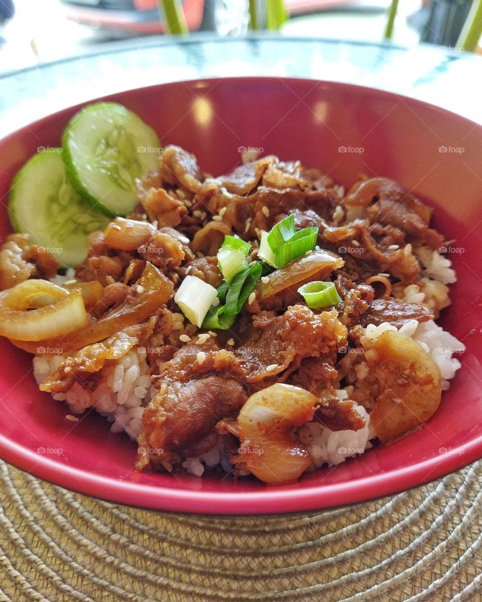 Beef teriyaki in a red bowl on a table
