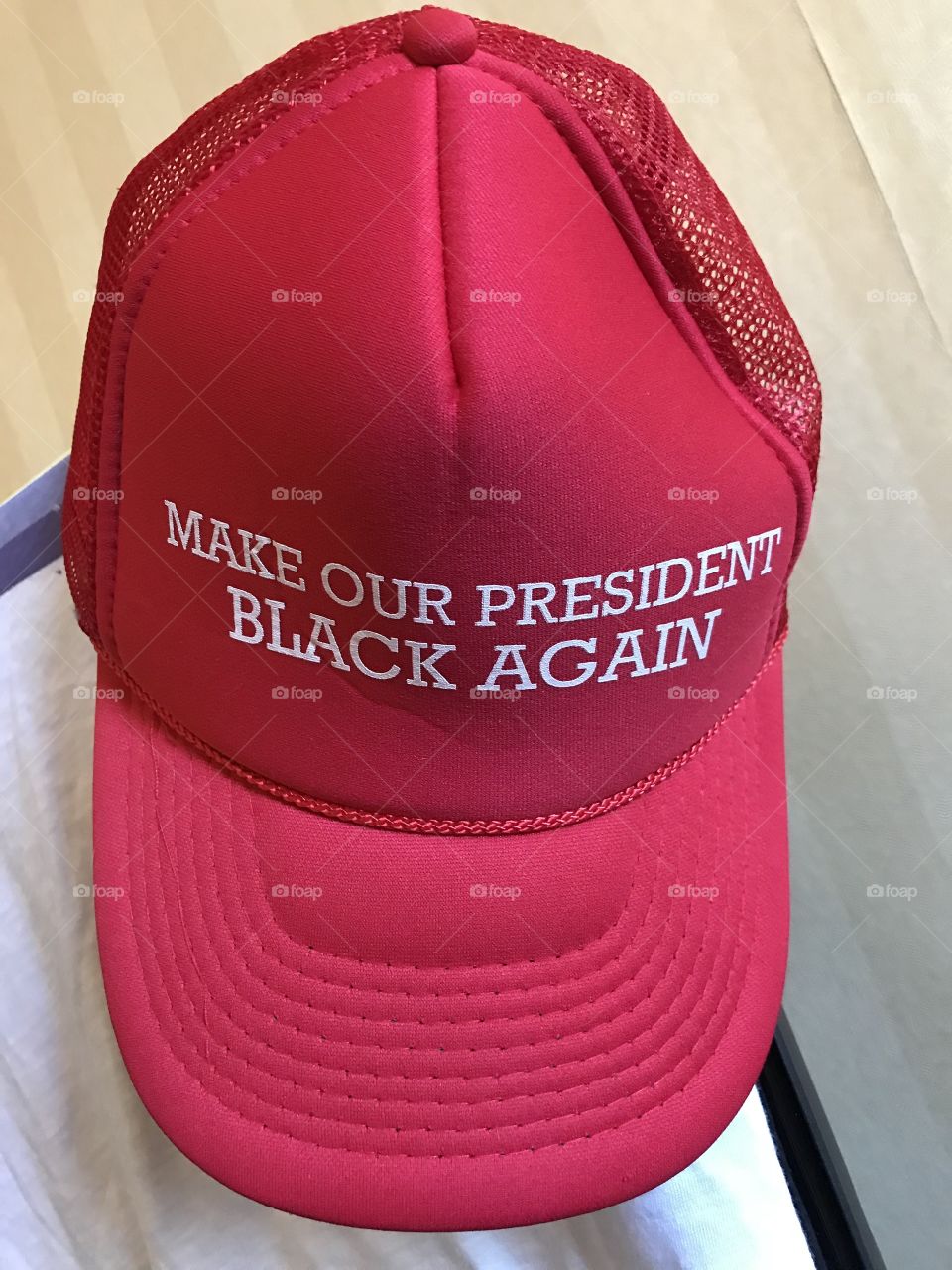 A red baseball cap with an anti trump slogan which says: make my president black again