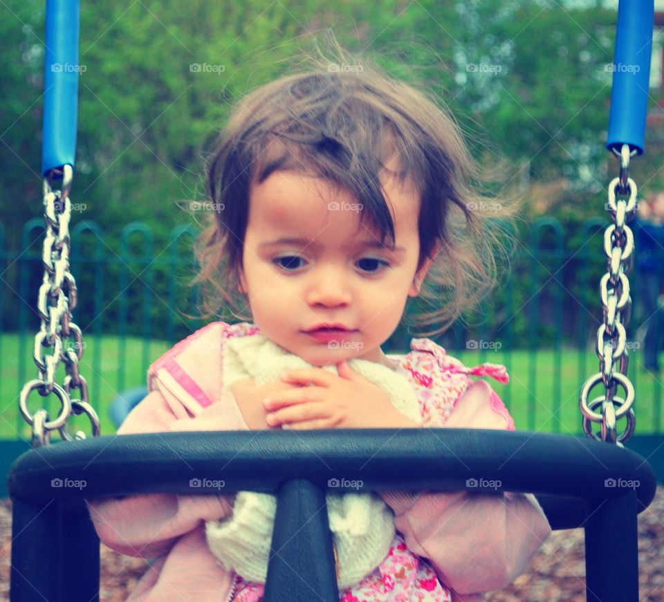 Deep in thought. My daughter on the swings 