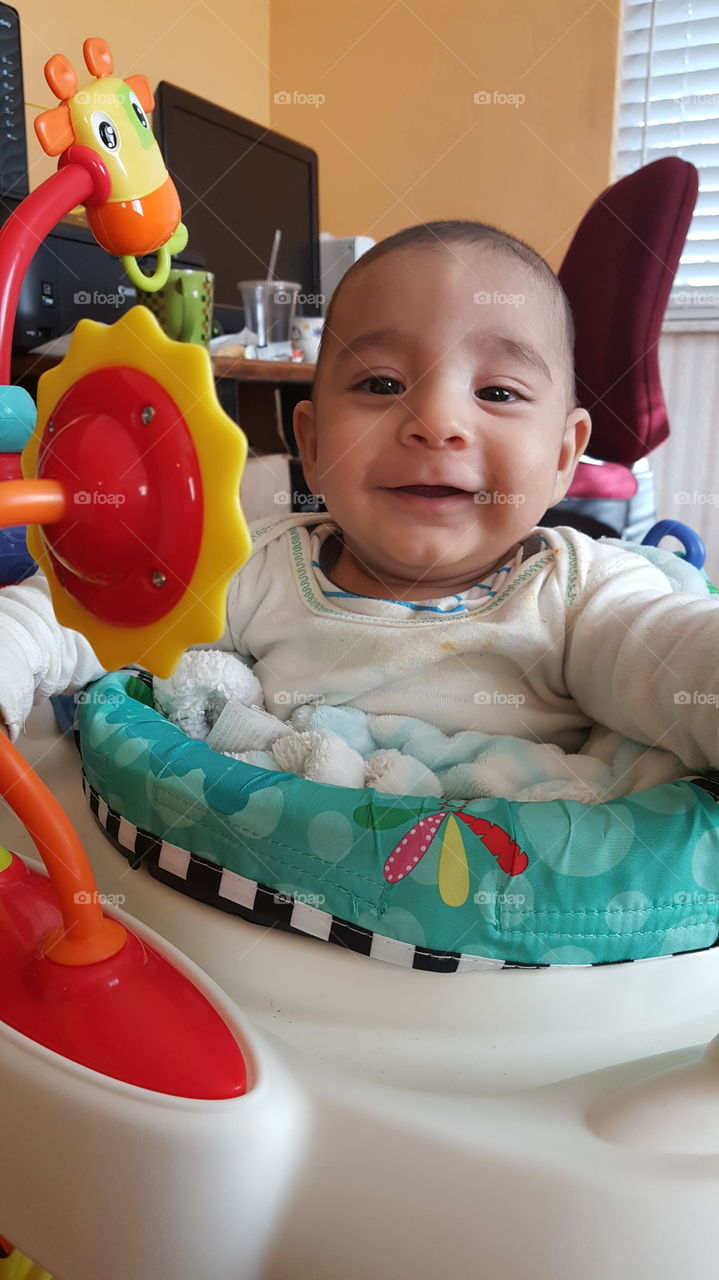 happy baby playing with his toys, cute smile brings joy to everyone.