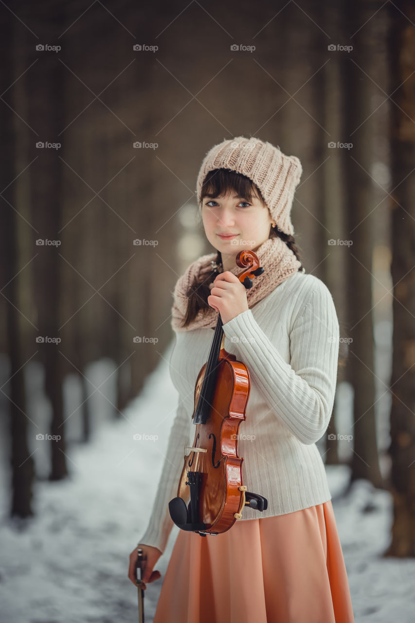 Teenage girl portrait with violin in winter park