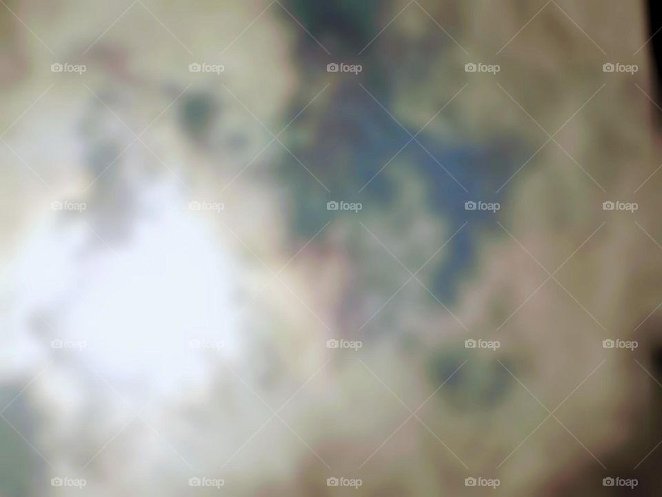 Blurry photo of the sun in the sky at noon