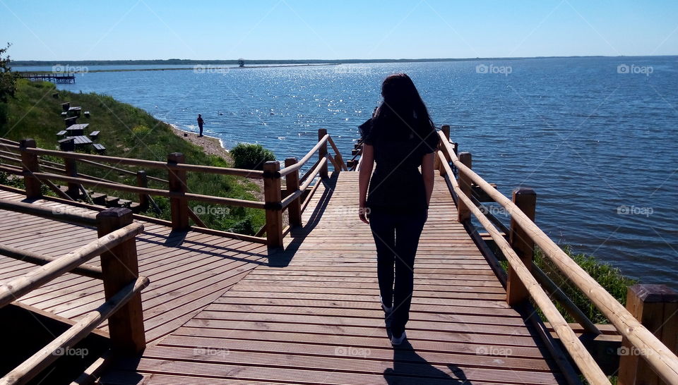 Women walking on a wooden bridge