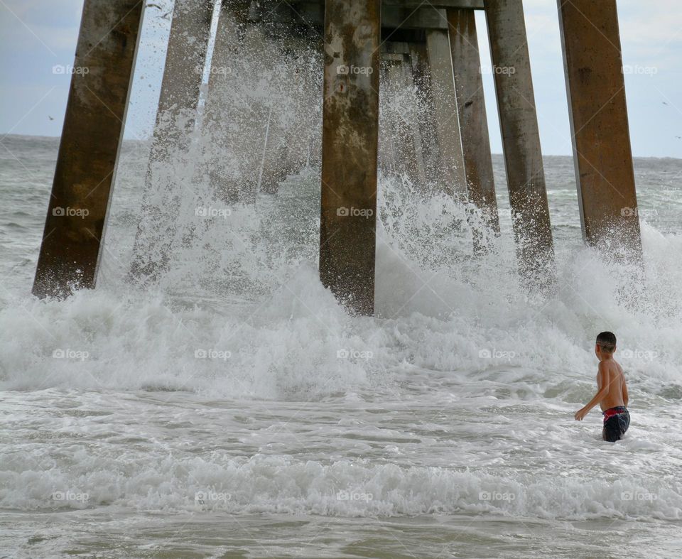  Liquids are cool - different liquids in different states and different situations - A boy watches as the Gulf of Mexico crashes the concrete pillars