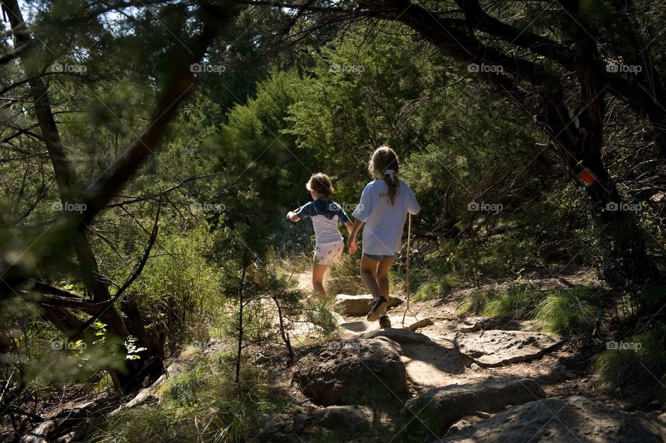 Two girls running down a mountain trail