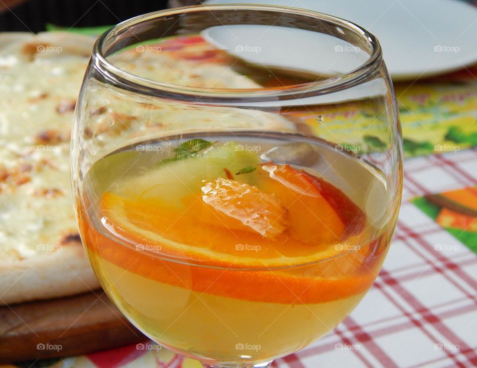 Circle glass with white Sangria with orange, peach and melon 