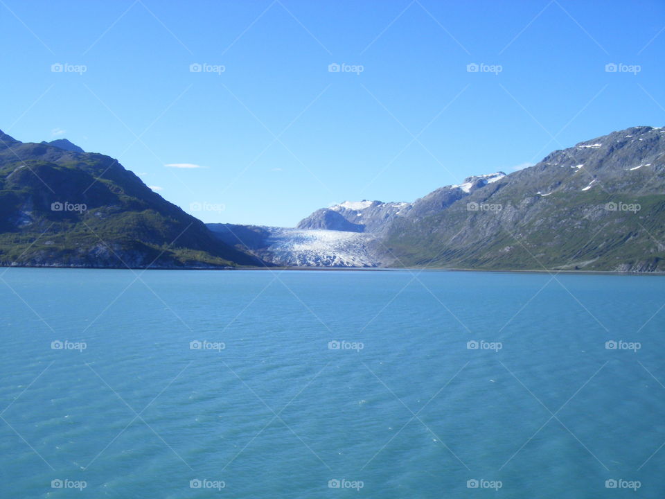 Mountain glacier and blue Ocean view on clear sunny day from cruise ship in Alaska