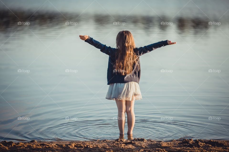 Little girl on lake coast