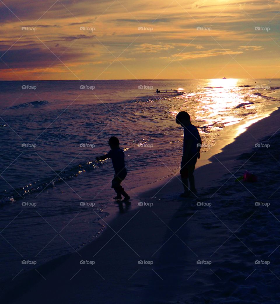 Boy having fun on the beach during sunset