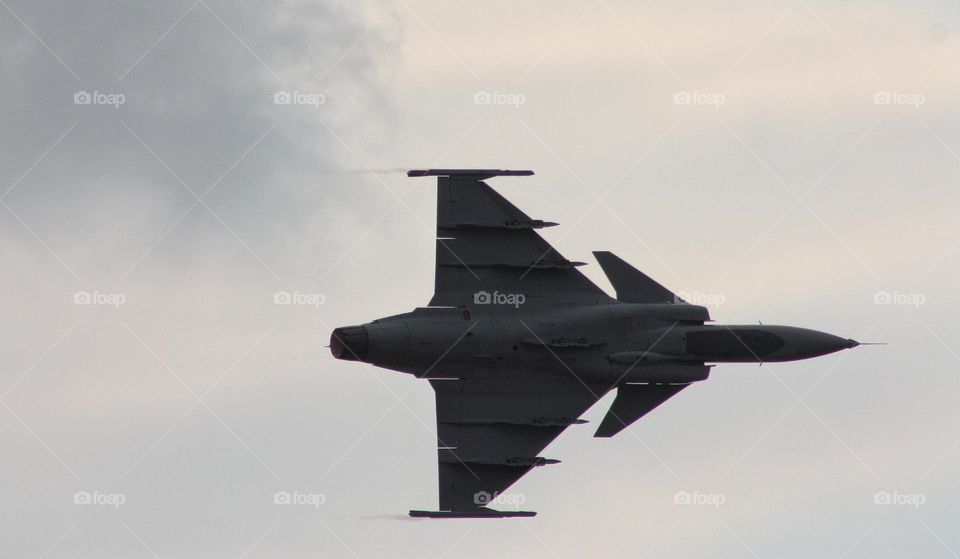 triangular shape of a fighter plane at speed in the afternoon.