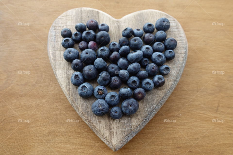 Close-up view of fresh Blueberries on a wooden heart