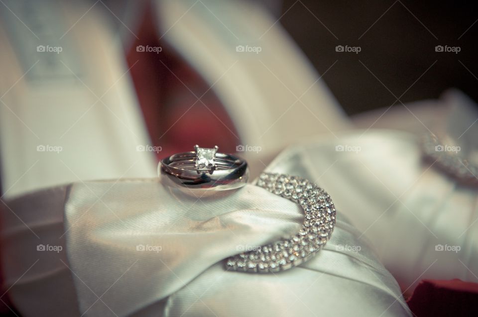 Rings sit gently on the wedding shoes.