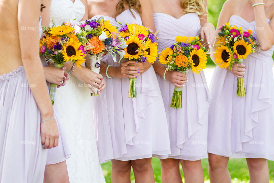 A bride and her bridesmaids hold their colourful bouquets