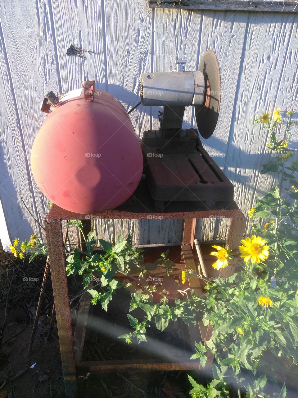 old antique table saw with an old air compressor on top