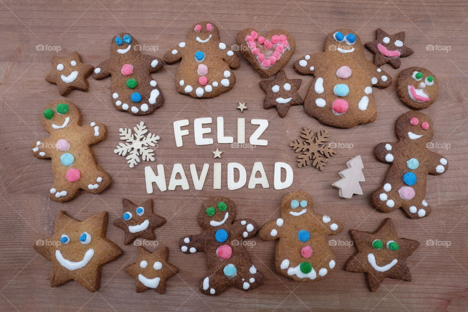 Feliz Navidad, spanish Merry Christmas message with gingerbread cookies and a creative text with wooden letters 