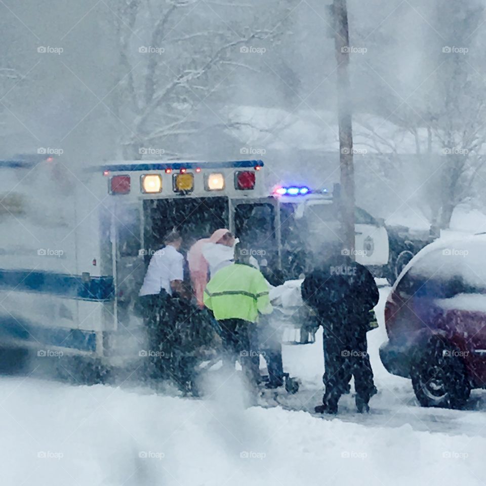 Ambulance, Emergency Ride To Hospital

Police & EMT lifting patient up into back of ambulance. Doors are wide open and in they go! Police car siren is making a howling noise as the blizzard goes on. Lights are flashing, they are in a hurry & I see one man has no coat on. It's freezing out. It is an emergency!