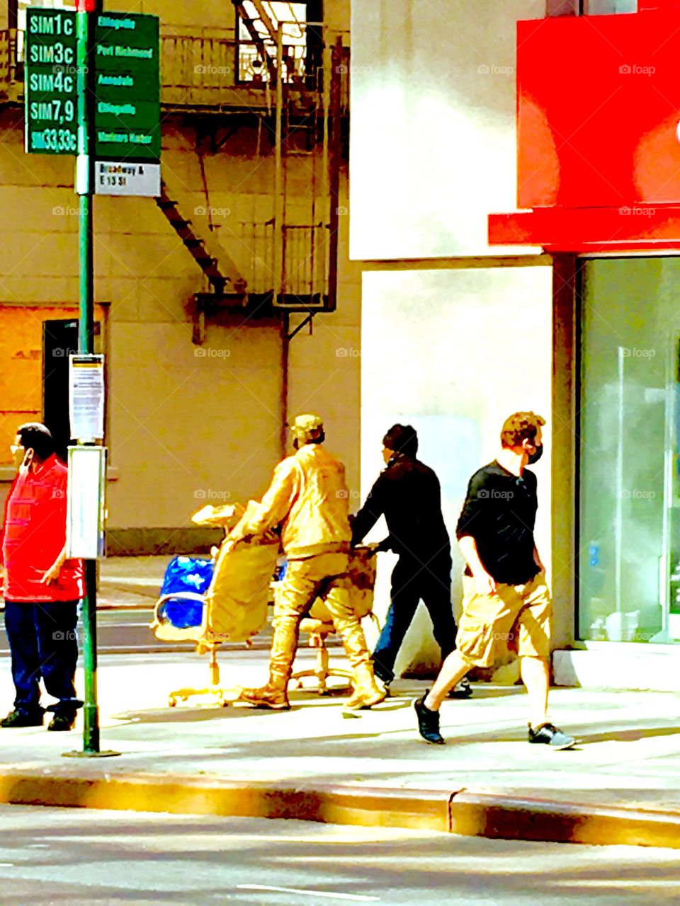 In NYC you can walk around for hours, see nothing out of the ordinary and then … suddenly … THIS !!! A pedestrian walking and pushing a cart but he is painted head to toe in bright metallic GOLD, his partner in black. 2020. Hypnotic Productions 