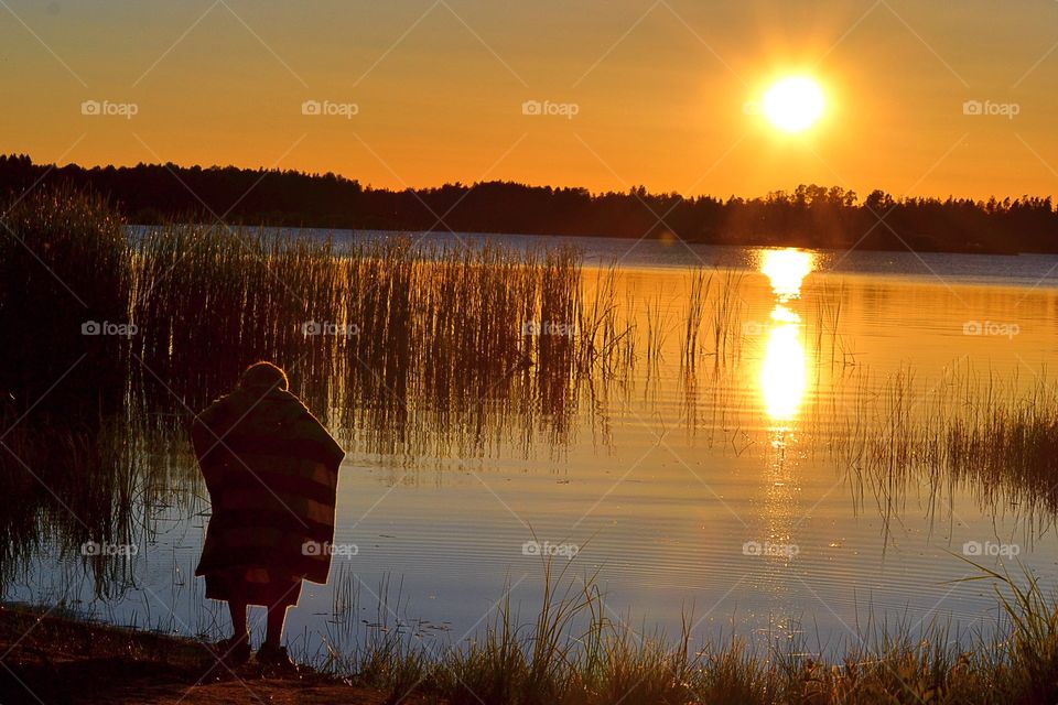 Sunset. Boy enjoying a time at the lake