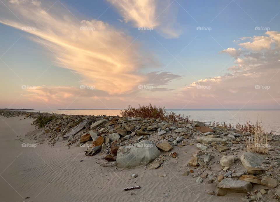 Pink and purple sunset on lake eerie shoreline on Cedar Point’s sandy, rocky beach 