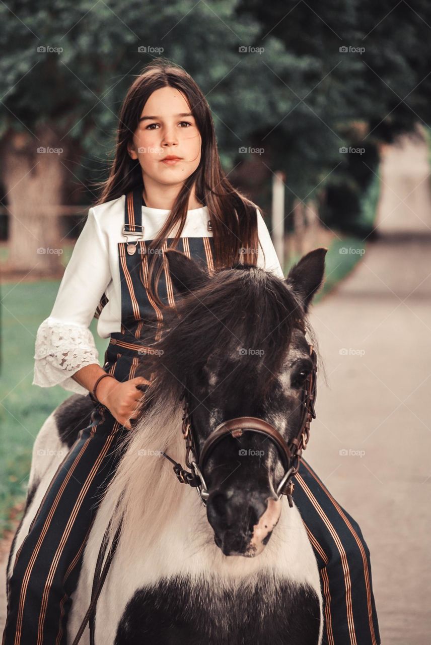 Teenage girl riding her horse in nature