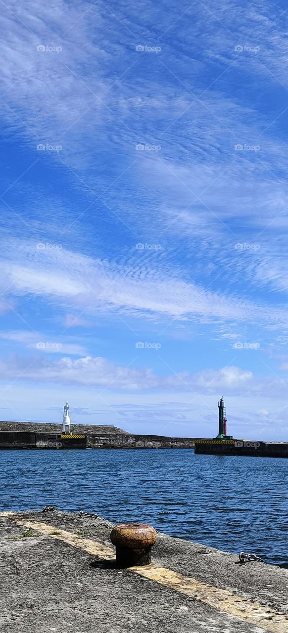 Lighthouse and blue sky with white clouds