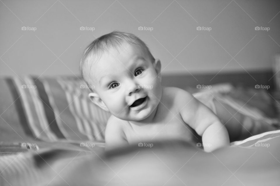 Baby girl playing and having fun in the bed.