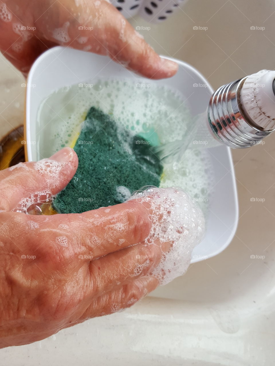 Close-up of woman's hand washing bowl