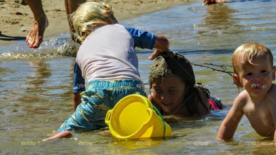Kids play on water and mud