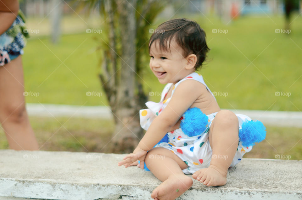 Smiling cute little girl sitting on bench