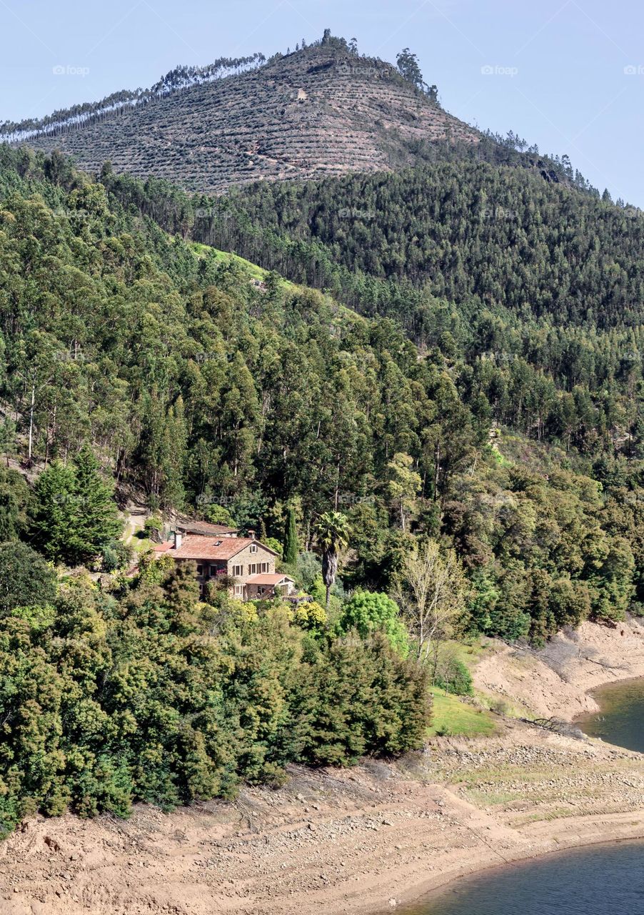 A stone cottage nestled at the foot of a mountain and on the banks of the Rio Zêzere, Central Portugal