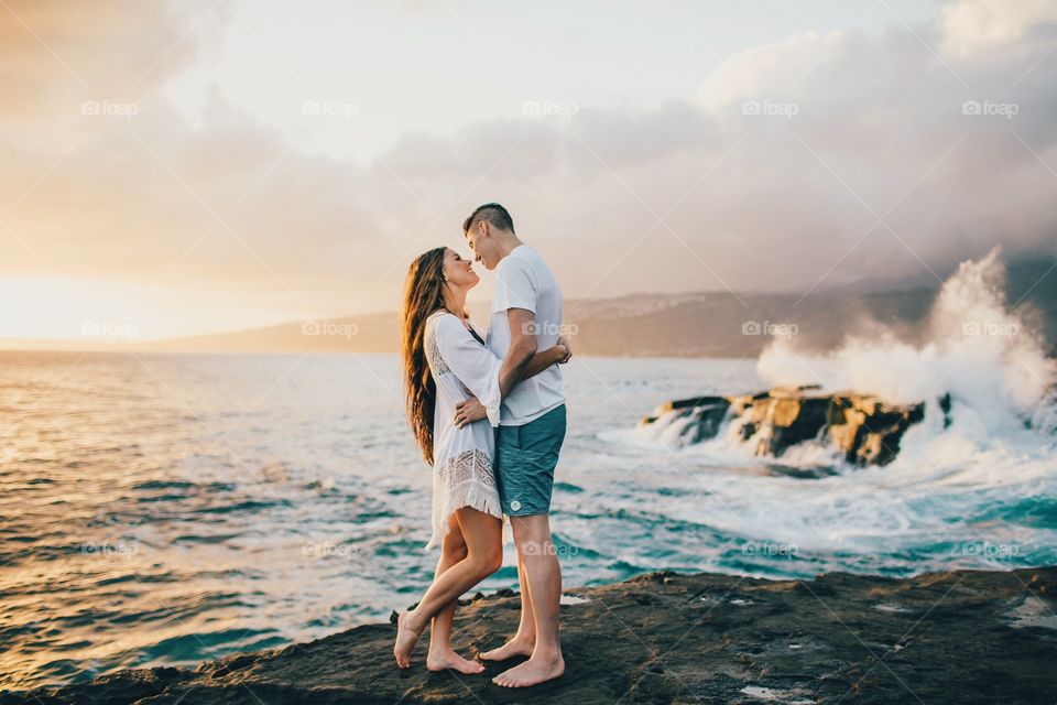 Couple standing on rock at coastline