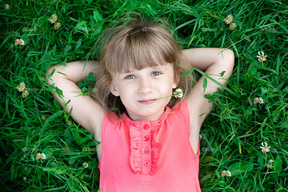 A little girl lying on grass