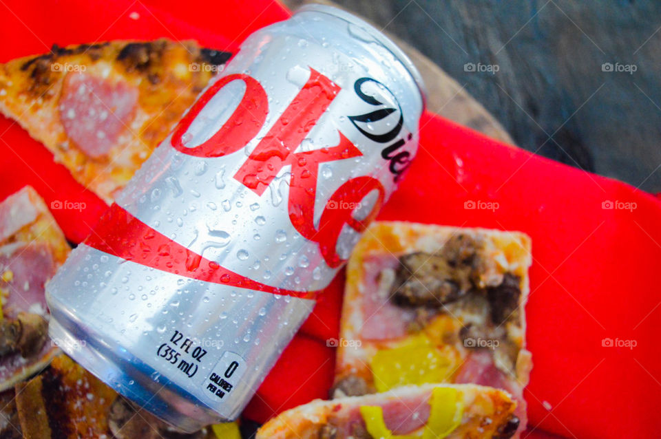 Diet Coke with pizza on a red and rustic background
