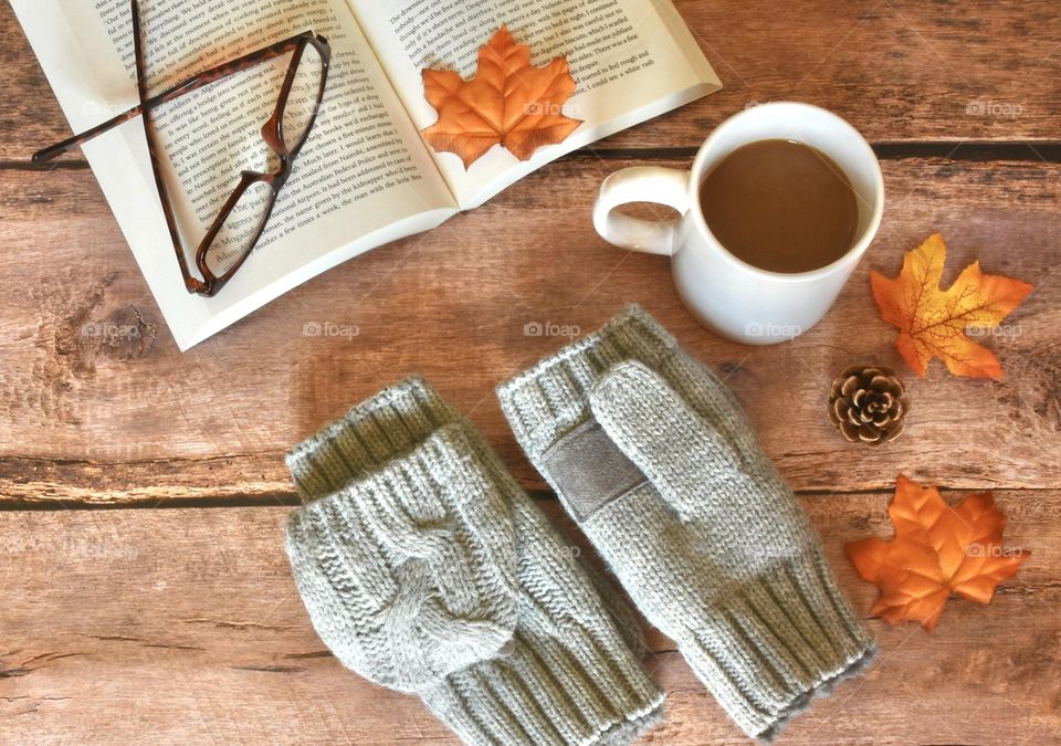 Autumn flat lay, still life with coffee, gloves, book, glasses and leaves