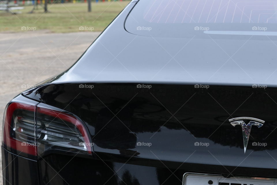 Automobile lines and features. Black back, taillight, window, hatch, features that make the machine.