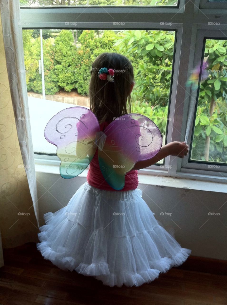 Rear view of girl looking through window