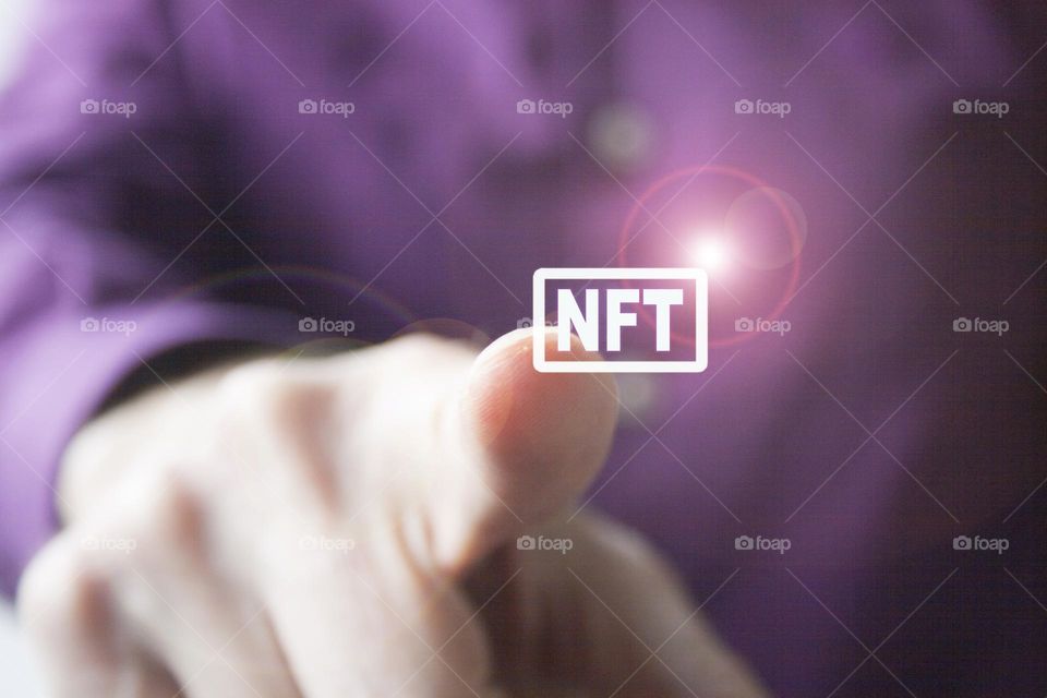 Man hand pressing a NFT virtual button