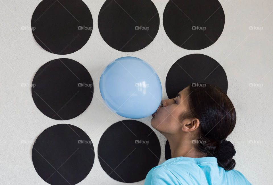 Blowing baby blue color balloon.